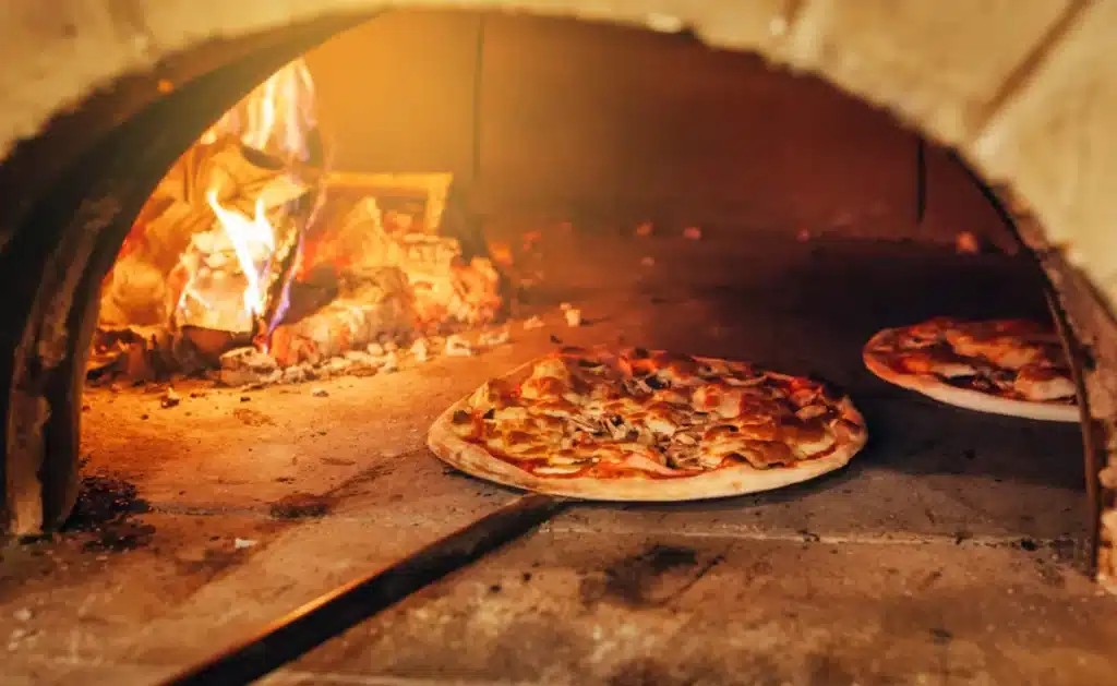 Pizza cuite au feu de bois dans un bar restaurant, avec une cuisson artisanale et des ingrédients savoureux.
